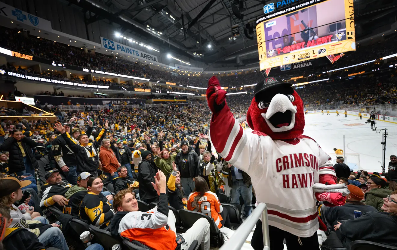 IUP mascot Norm posing for the camera amongst a crowd of hockey fans at PPG Paints Arena.