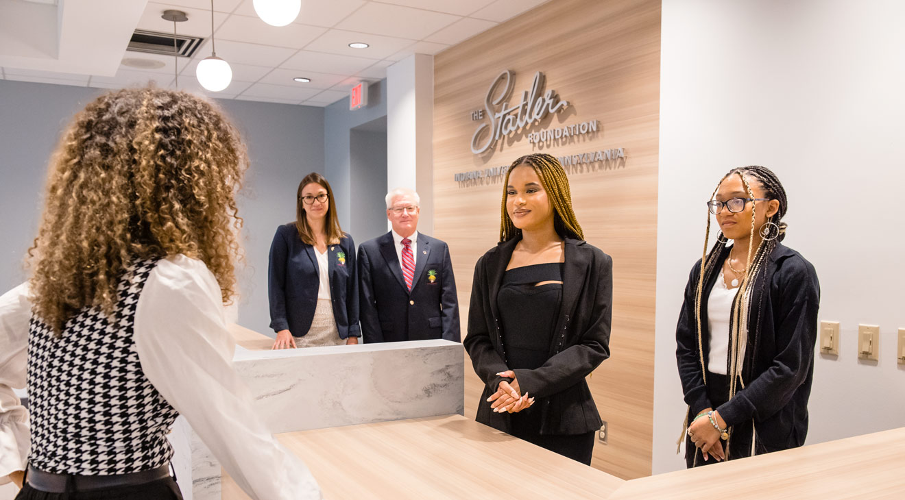 A group of students standing at the new eberly hotel desk