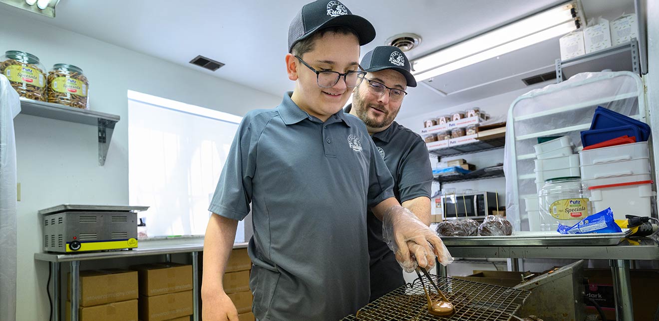 Jake Haney, 15, with his father, Roger, in the Spectrum Fudge factory