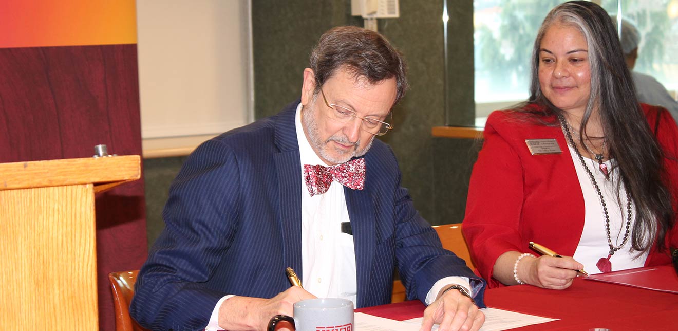 President Driscoll and Miko Rose signing agreement