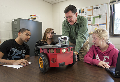 A professor and students with a robot