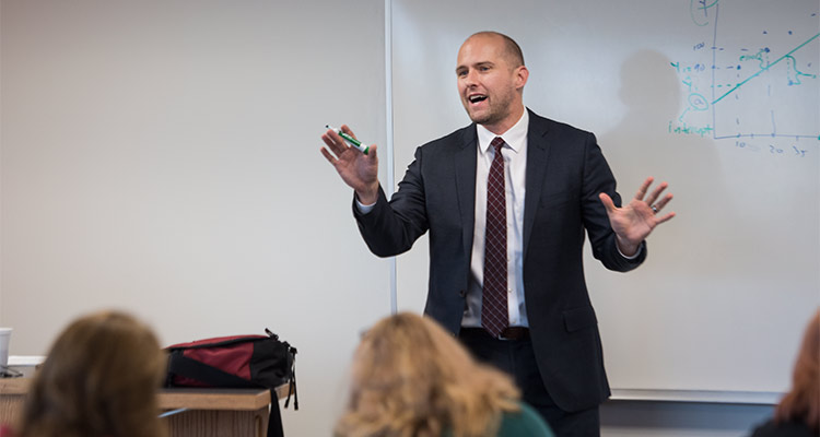 A man stands in front of a whiteboard during an MBA class at IUP