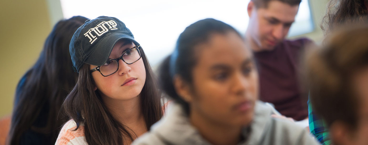 several students in a classroom with a female student in focus in the center