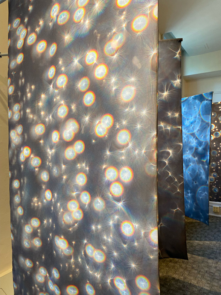 Photograph of several art panels depicting star like images.
