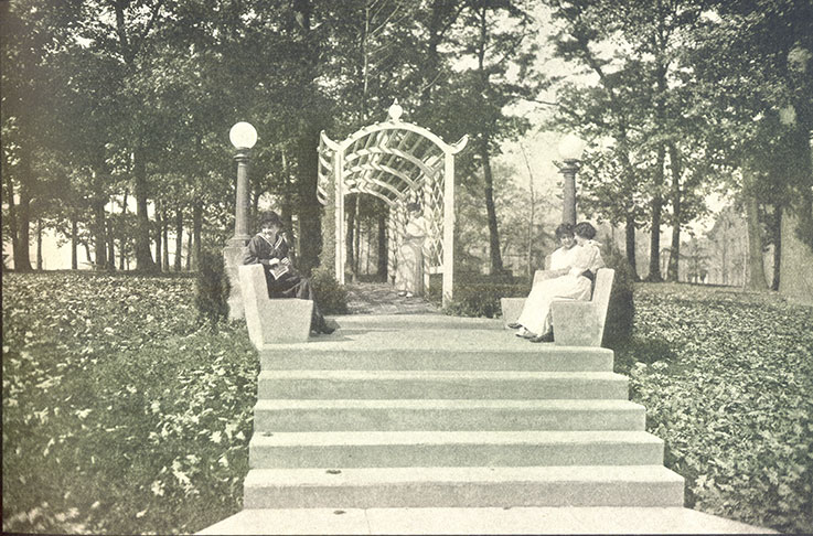photographic image of ladies sitting on benches in IUP's Oak Grove