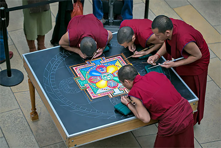 monks create sand mandala art