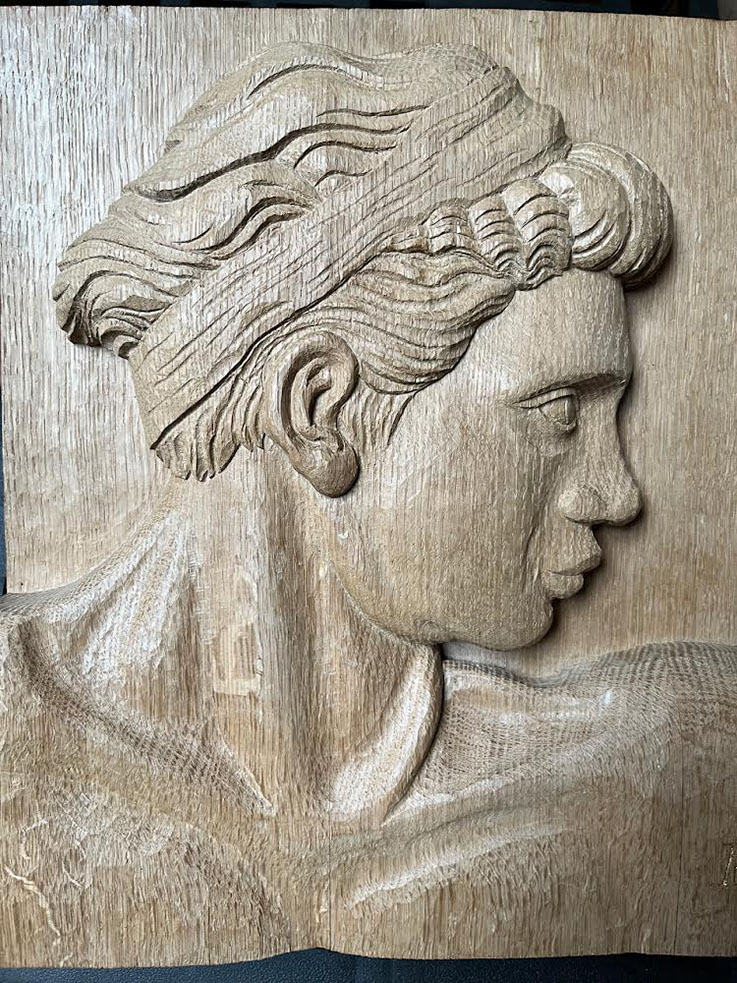 wooden relief carving of a human face