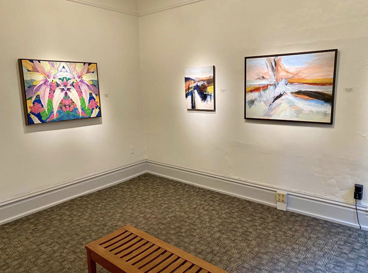 photographic image of the corner of a gallery in the University Museum artistic works are hung on the walls