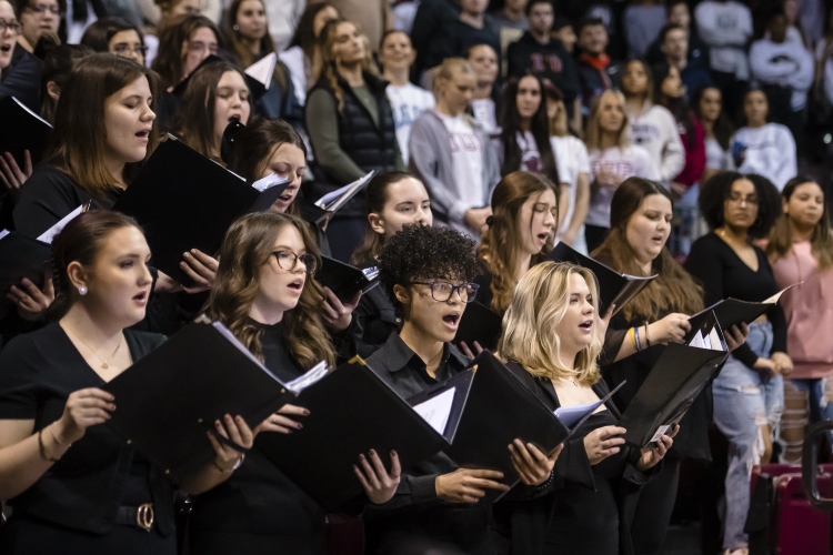 IUP Chorale and the IUP Chorus students singing in unison at an IUP basketball game.