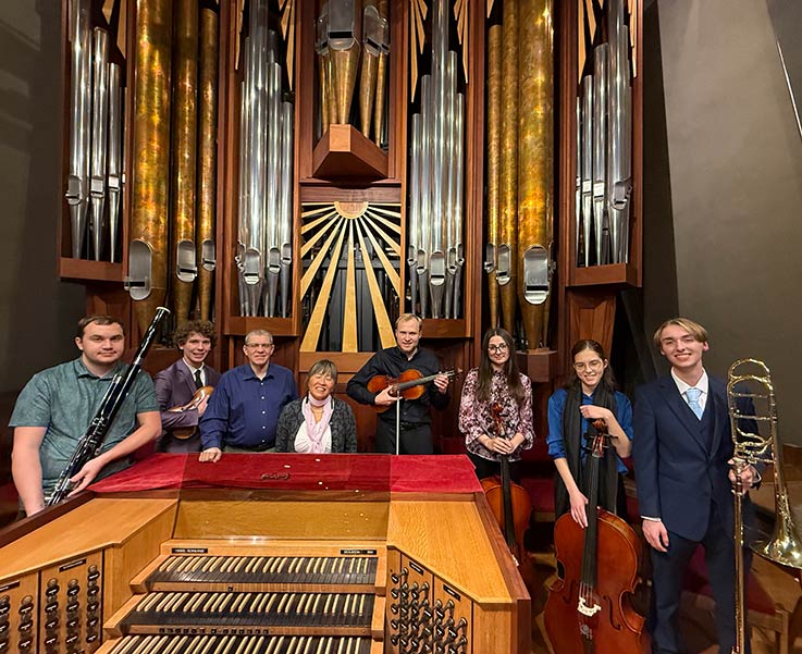 Christine Clewell and IUP students at the Fish Church with the church’s sub-dean, Kevin Bailey, in front of the Visser-Rowland pipe organ