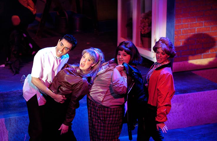 group of four students performing on stage