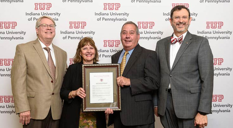 IUP Trustee Tim Cejka, at left, present Audrey and Dr. Bill Madia with the resolution naming the IUP Department of Chemistry as the Madia Department of Chemistry. IUP President Dr. Michael Driscoll
