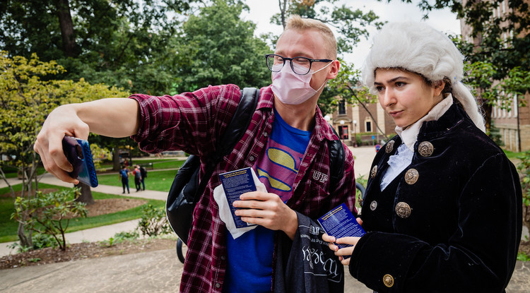 a student taking a selfie with someone dressed as a founding father
