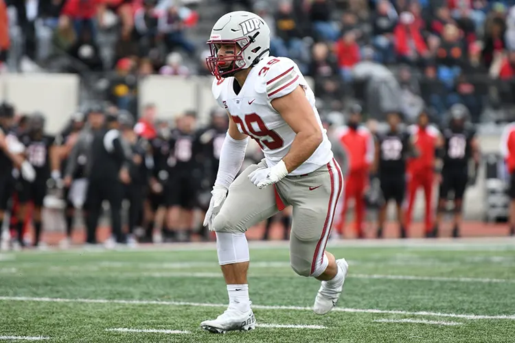 Drew Dinunzio-Biss in pads running on the football field.