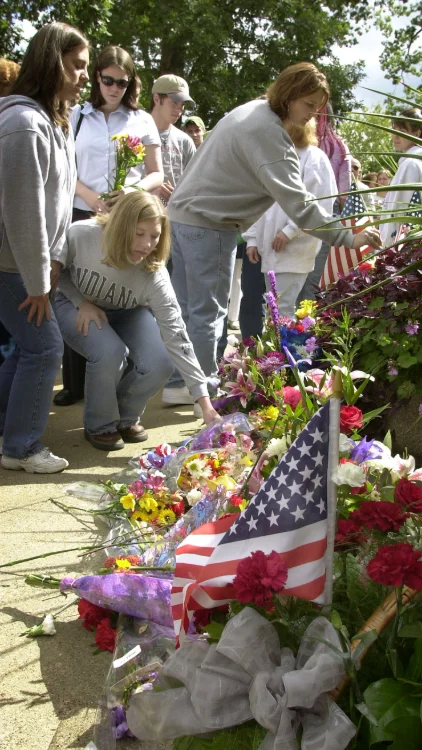 Students adding to an ever-growing pile of flowers and small American flags during the 9/11 memorial