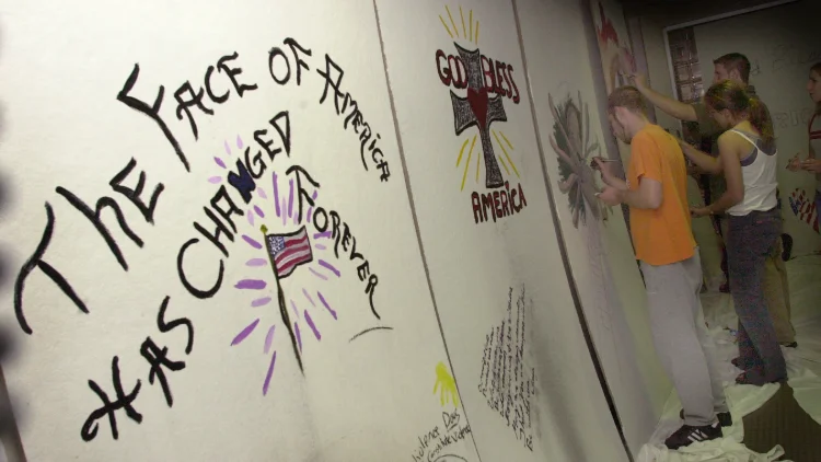 Close of students working on a wall mural to honor those lost in 9/11