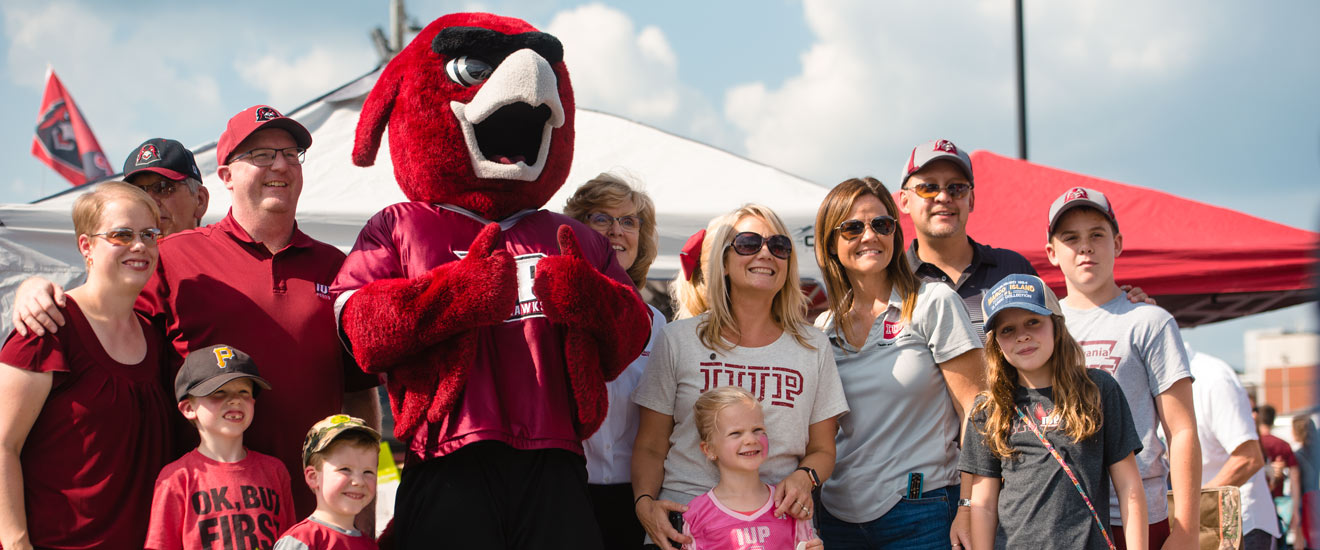a large family poses with Norm during Family Weekend