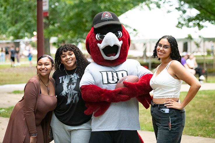 Three students in the Oak Grove with Norm, the IUP mascot