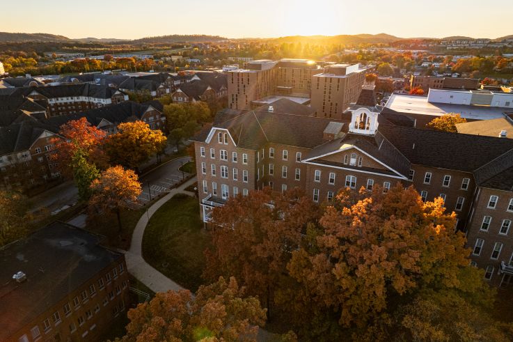 Aerial view of Sutton Hall and the IUP campus with a sunset in the background