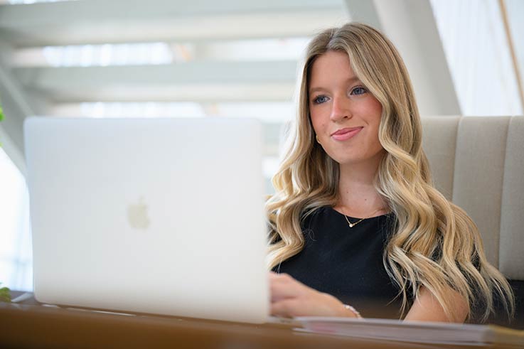 A student sitting and working on a laptop computer