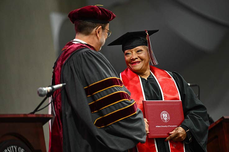 Aretha Swift on the Commencement stage with IUP President Michael Driscoll