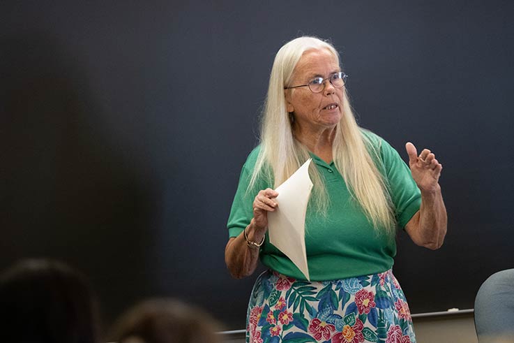 Arlene Eva Langley-Mendenhall standing before a chalkboard and speaking at the front of a classroom