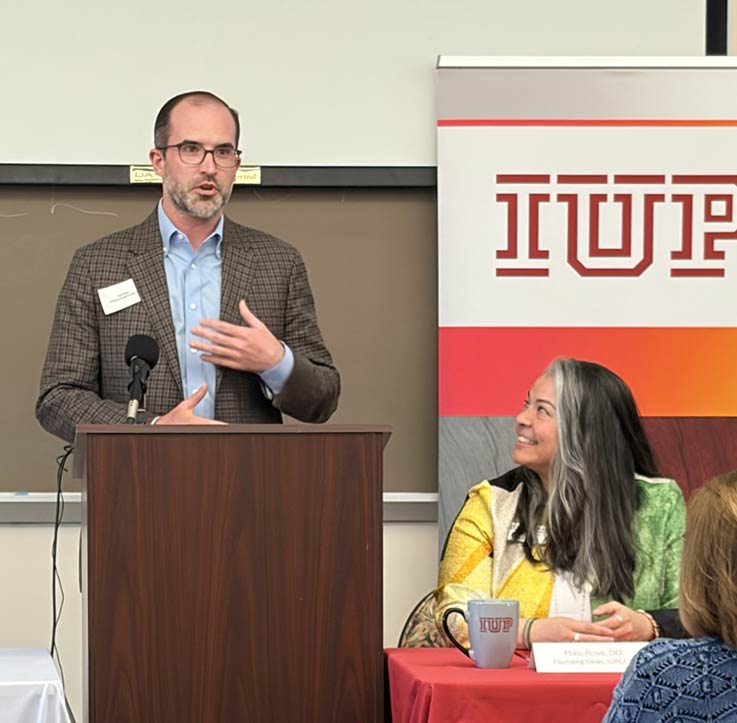 Primary Health Network Chief Financial Officer Carl Sizer III at podium, and IUP proposed college of osteopathic medicine Founding Dean Miko Rose