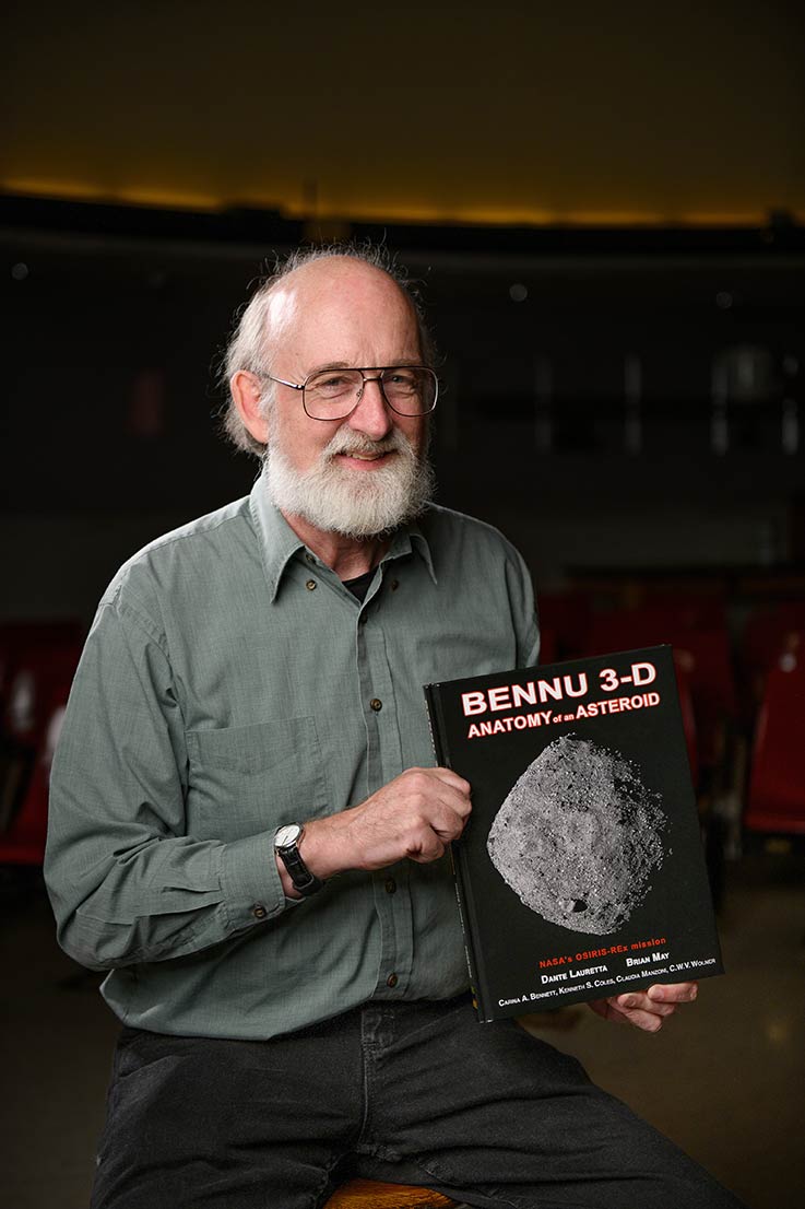 Ken Coles holding a copy of his book "Bennu 3-D: Anatomy of an Asteroid"