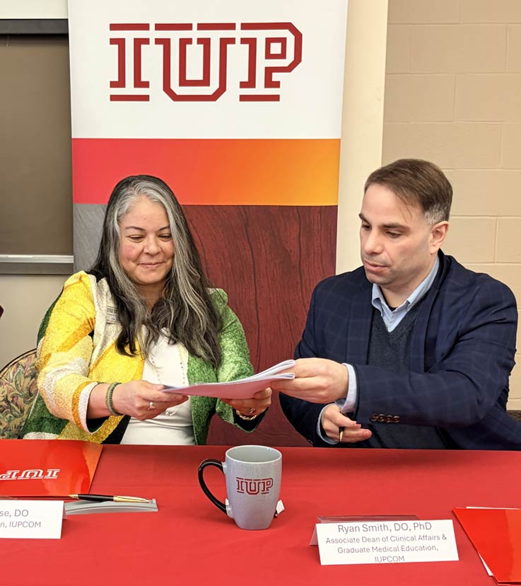 Miko Rose, right, and Ryan Smith signing the agreement