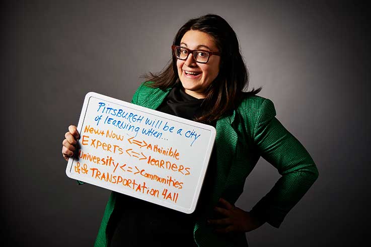 Nina Barbuto holding a sign describing when Pittsburgh will be a city of learning 