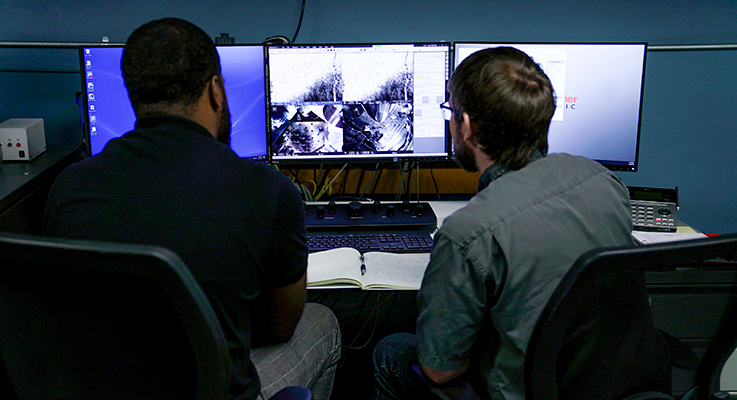 Physics students viewing research on computer screens 