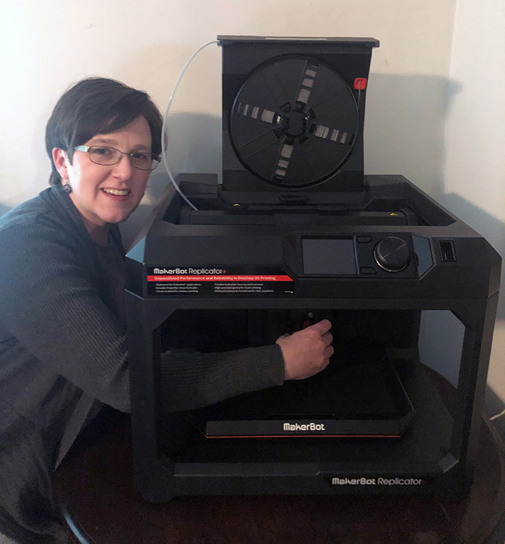Annah Hill with one of the 3-D printers in the College of Education and Communications 