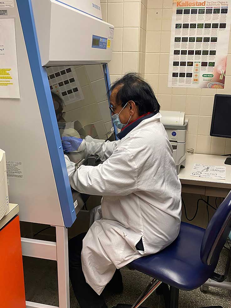 Dr. N. Bharathan working under a safety shield