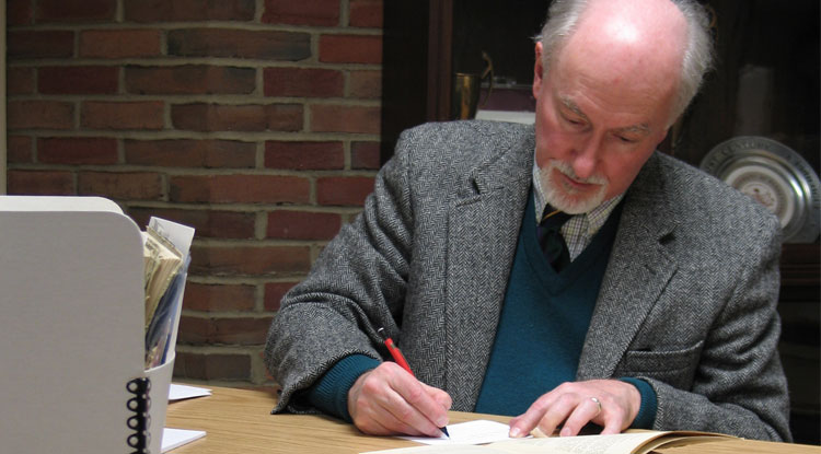 Charles Cashdollar takes notes while reviewing copies of the Normal Herald, the alumni bulletin from 1895 to 1927, in the IUP Libraries' Special Collections and University Archives area