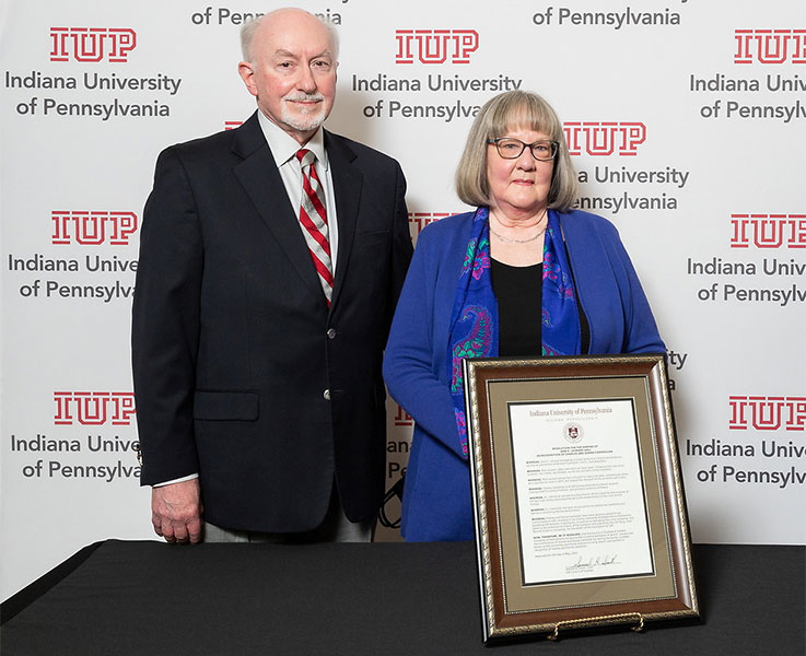 Charles and Donna Cashdollar standing behind a framed resolution