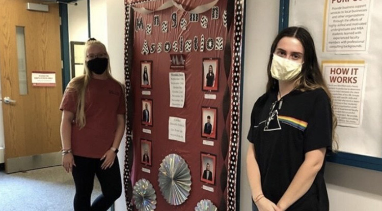 Sarina Steigerwald, left, and Danielle Hobbins recently decorated the organization board in Eberly in recognition of the Management Association.