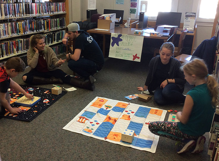 IUP resident assistants helping children in the library