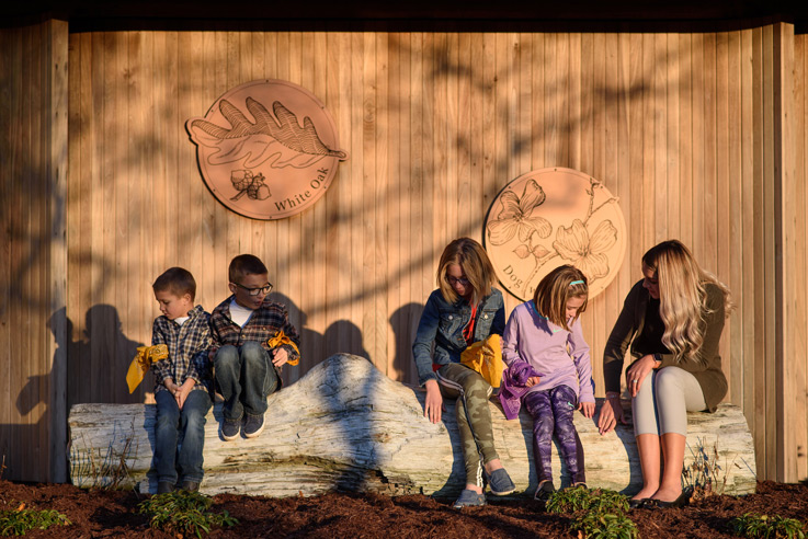 A student working with children in the Larry F. Sobotka Science Discovery and Outdoor Learning Center