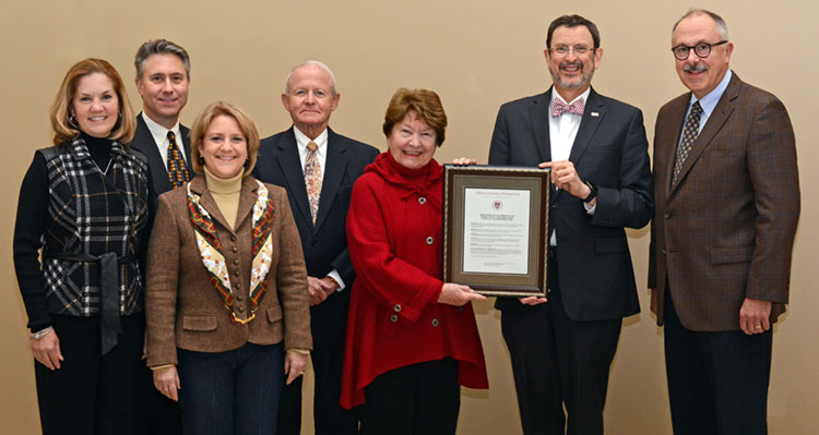 Members of the Mackey family with the resolution approved by the Council of Trustees to name the Mackey Family Charitable Trust Financial Trading Room
