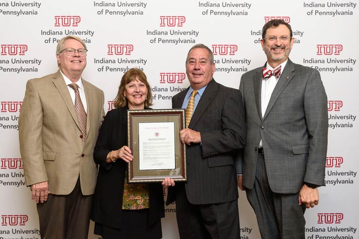IUP Trustee Tim Cejka, at left, present Audrey and Dr. Bill Madia with the resolution naming the IUP Department of Chemistry as the Madia Department of Chemistry. IUP President Dr. Michael Driscoll