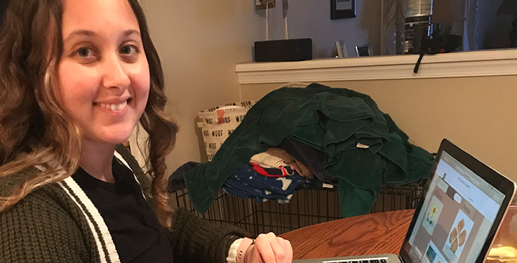 Megan Caton sits at her makeshift work station at the dining room table in her parents' house.