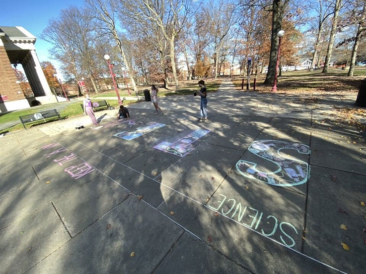 National Art Education Association members created chalk art outside Fisher Auditorium last fall to promote the “A” (art) in STEAM. From left: Sydney Huston, Davey Beyer, Tristan Croyle, and Jen Freno. National Art Education Association members created chalk art outside Fisher Auditorium last fall to promote the “A” (art) in STEAM. From left: Sydney Huston, Davey Beyer, Tristan Croyle, and Jen Freno.