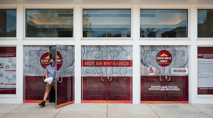 At North Dining, window decals guide students on where to enter and exit to maintain a safe distance from others. 