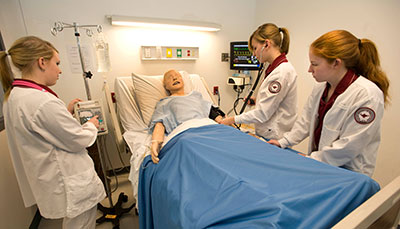 Nursing students work with a manikin in the Johnson Hall nursing simulation laboratory. (Keith Boyer photo)