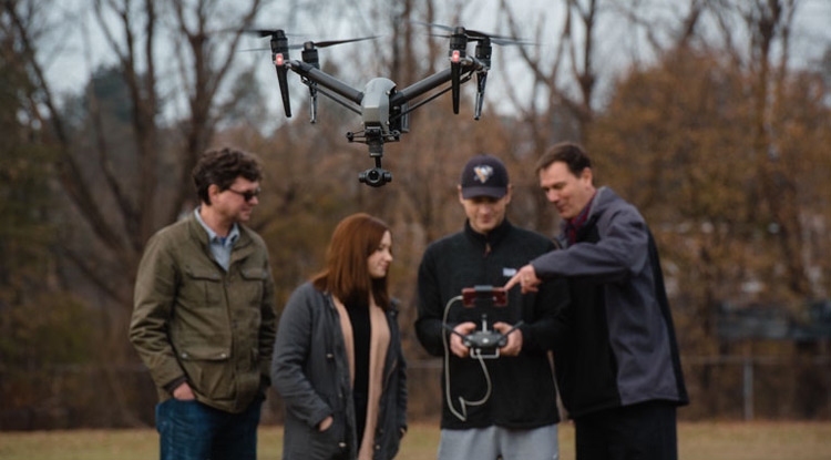 Faculty members Christopher Schaney, left, and John Benhart, right, flew a drone with Kate Marodi and Jordan Hudzicki in November.
