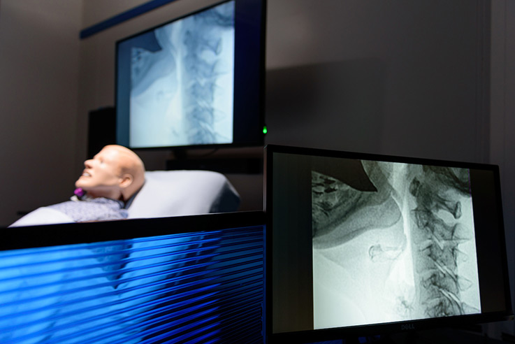 Students and faculty members get the look and feel of a real hospital room, with images of procedures projected onto monitors.