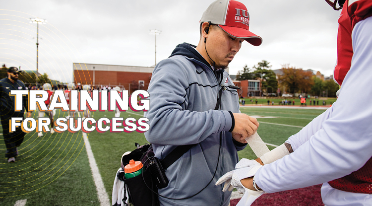 An IUP employee applying athletic tape to a football player's wrist