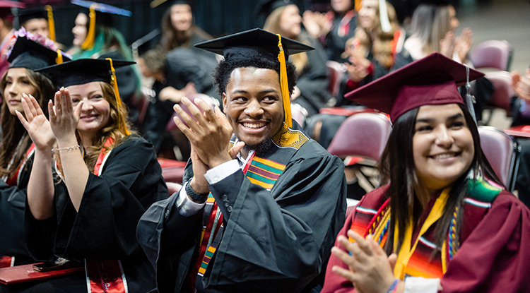 students clapping during commencement