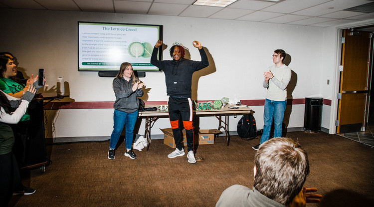 A student celebrating his victory in a lettuce eating competition