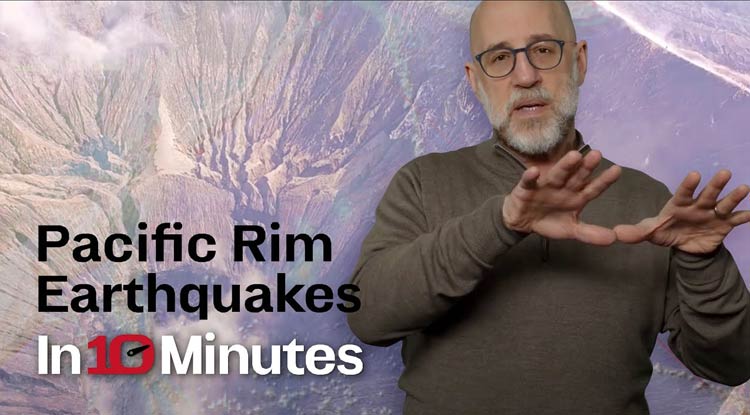 Jon Lewis standing in front of a backdrop containing an aerial photo.  The words Pacific Rim Earthquakes In 10 Minutes are on the bottom left corner.